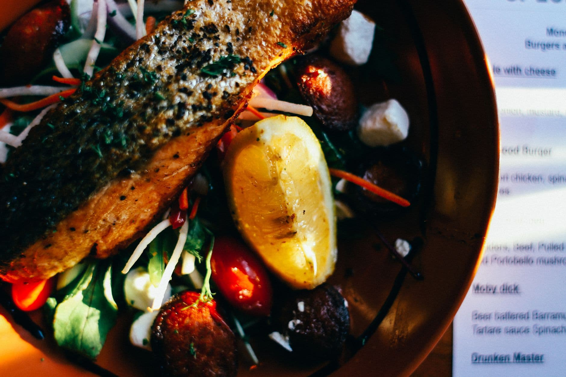 prato com salmão grelhado, salada de folhas, tomate e limão