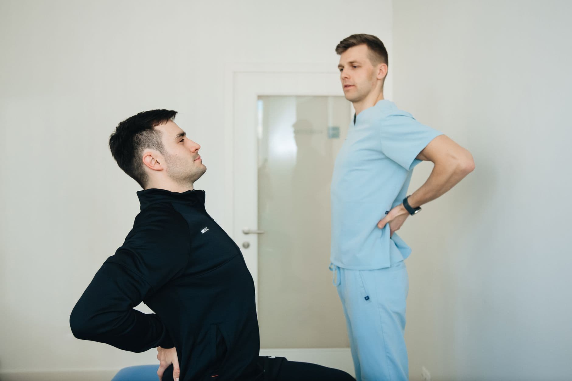 fisioterapeuta orientando um paciente em exercícios para as costas no consultório
