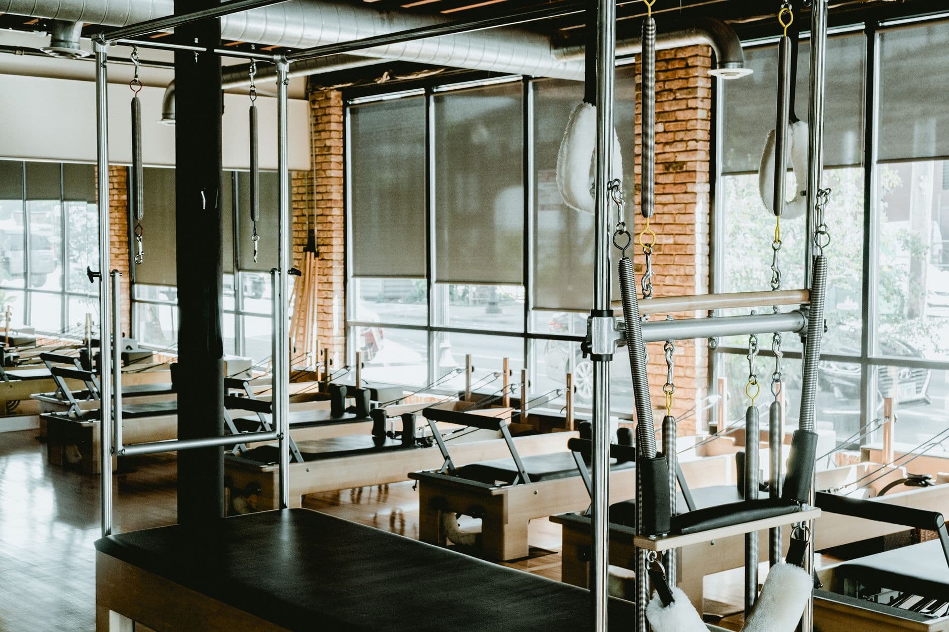 estúdio de pilates com aparelhos alinhados perto das janelas