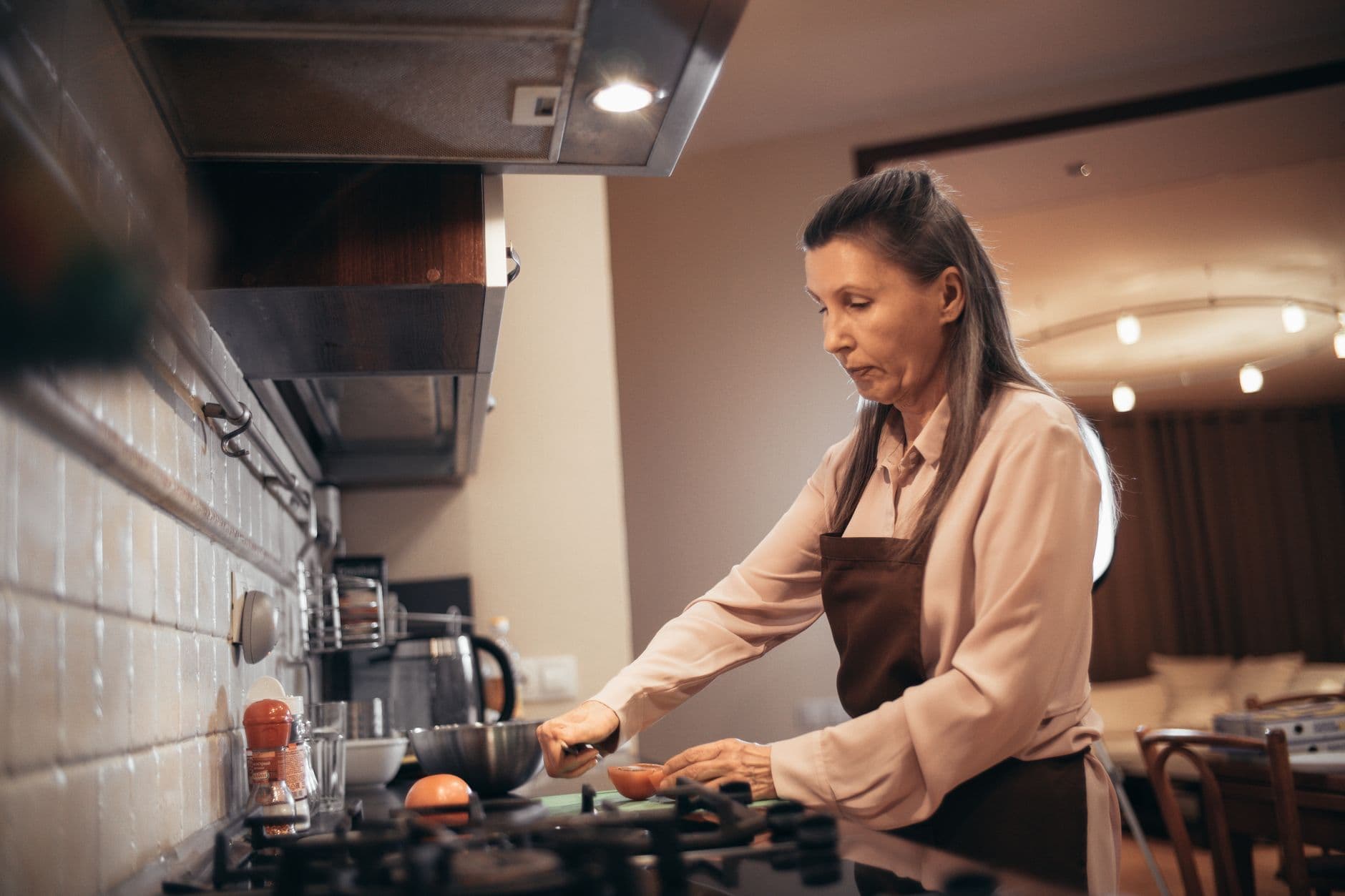 mulher preparando comida no fogão da própria cozinha