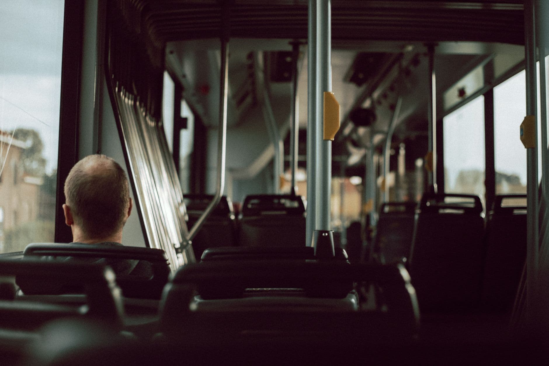 homem sentado junto à janela de um ônibus durante a viagem